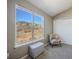 Bright bedroom showcases a floral accent chair, plush carpet, and lovely mountain views through a large window at 114 Vale St, Palmer Lake, CO 80133
