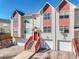 Inviting townhome showcasing a red staircase and a clean, two-car garage for convenient parking and curb appeal at 114 Vale St, Palmer Lake, CO 80133