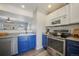 Modern kitchen with stainless steel appliances, blue lower cabinets, and an open layout for seamless cooking and entertaining at 114 Vale St, Palmer Lake, CO 80133
