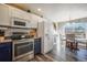 Charming kitchen boasting white upper cabinets, stainless steel appliances, and an adjacent dining area with ample natural light at 114 Vale St, Palmer Lake, CO 80133