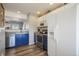 Well-lit kitchen equipped with stainless steel appliances, stylish blue lower cabinets, and a convenient open layout design at 114 Vale St, Palmer Lake, CO 80133