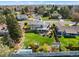 Aerial view of a large backyard with a lush green lawn, patio area, garden, and surrounding neighborhood at 3191 S Holly Pl, Denver, CO 80222