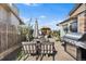 Backyard patio with a dining table, umbrella, grill, and blooming trees, perfect for outdoor entertaining at 3191 S Holly Pl, Denver, CO 80222