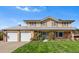 Charming two-story home with a well-manicured lawn, two-car garage, and light beige siding at 3191 S Holly Pl, Denver, CO 80222