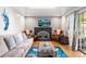 Living room featuring hardwood floors, stone fireplace, and plenty of seating at 3191 S Holly Pl, Denver, CO 80222