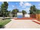 Wide shot of backyard featuring two storage sheds, a gravel bed, concrete pad, grass, and a wood fence at 1455 W Alaska Pl, Denver, CO 80223