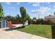 Landscaped backyard featuring a well-maintained lawn, a blue shed, and a wood fence surrounding the property at 1455 W Alaska Pl, Denver, CO 80223