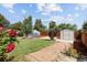 A backyard view featuring a brick pathway, shed, and wood fence at 1455 W Alaska Pl, Denver, CO 80223