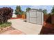 Backyard view of a gray storage shed set on a concrete pad, with a mulched bed at 1455 W Alaska Pl, Denver, CO 80223
