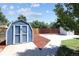 View of a blue storage shed and a gray shed on a concrete pad with a wood fence in the background at 1455 W Alaska Pl, Denver, CO 80223