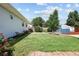 Landscaped backyard featuring a well-maintained lawn, a blue shed, and a wood fence surrounding the property at 1455 W Alaska Pl, Denver, CO 80223