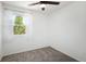 Bedroom with carpet, ceiling fan and window overlooking lush outdoor foliage at 1455 W Alaska Pl, Denver, CO 80223