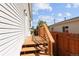 Wood deck leading to backyard, with railing and steps, and a light fixture on the exterior wall of the house at 1455 W Alaska Pl, Denver, CO 80223