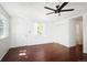 Bright living room featuring hardwood floors, a ceiling fan, and ample natural light at 1455 W Alaska Pl, Denver, CO 80223