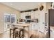 Bright kitchen features white cabinets, stainless steel appliances, and a quartz island with stools at 12815 Randles Ave, Parker, CO 80134