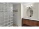 Bathroom featuring a tiled walk-in shower with glass block and modern vanity at 3232 Cimarron Pl, Superior, CO 80027