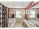 Bright bathroom with a double sink vanity, a soaking tub, and a decorative shower curtain at 3232 Cimarron Pl, Superior, CO 80027