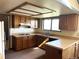 A quaint kitchen with wood cabinets, beige countertops, and modern appliances provides function and efficiency at 11323 E Cimmarron Dr, Englewood, CO 80111