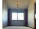 This living room features tall windows and a contemporary chandelier at 11323 E Cimmarron Dr, Englewood, CO 80111