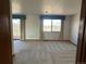 Bright living room with large windows and neutral carpet, leading to outdoor deck at 11323 E Cimmarron Dr, Englewood, CO 80111