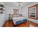 Cozy bedroom featuring hardwood floors, two windows, and comfortable furnishings at 3057 S Fox St, Englewood, CO 80110