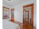 Bright bedroom with hardwood floors, large windows, and a view of the hallway at 3057 S Fox St, Englewood, CO 80110