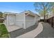 Side view of home featuring light gray siding, a white door, and a concrete walkway to a fenced backyard at 3057 S Fox St, Englewood, CO 80110