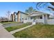 Lovely exterior view of a bungalow-style home with a well-maintained front lawn, driveway and nearby new construction at 3057 S Fox St, Englewood, CO 80110