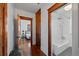 Hallway with hardwood floors leading to a bedroom and bathroom with a standing shower at 3057 S Fox St, Englewood, CO 80110