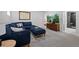Cozy living room with soft carpet, plush blue sectional sofa, and entertainment center at 3057 S Fox St, Englewood, CO 80110