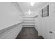 Bright walk-in closet with white walls, shelves, hanging rods, and overhead lighting at 3057 S Fox St, Englewood, CO 80110