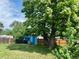 Backyard featuring a large tree, blue shed, and wooden fence at 1701 W 50Th Ave, Denver, CO 80221