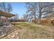 Spacious backyard featuring a stone patio, mature trees, and a privacy fence at 1701 W 50Th Ave, Denver, CO 80221