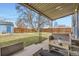 Inviting backyard with covered patio, ideal for outdoor relaxation and entertainment with a large tree in the yard at 1701 W 50Th Ave, Denver, CO 80221