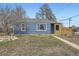 Charming home with blue siding, mature landscaping, and inviting front porch offers curb appeal at 1701 W 50Th Ave, Denver, CO 80221