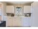 Functional kitchen featuring white cabinets, ample counter space, and natural light from the window at 1701 W 50Th Ave, Denver, CO 80221