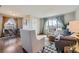 Inviting open-plan living room with a view of the dining area, featuring hardwood floors and stylish, neutral-toned furniture at 1701 W 50Th Ave, Denver, CO 80221