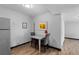 Cozy dining area includes table, chairs, wood-look flooring, and yellow floral wall art at 1606 Cottonwood Dr # 24S, Louisville, CO 80027