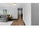 Open-concept layout with wood floors connecting the living area to a hallway leading to the kitchen at 1606 Cottonwood Dr # 24S, Louisville, CO 80027