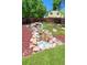 Tranquil backyard featuring a rock waterfall, lush greenery, and mature trees at 12935 Lake Circle Dr, Thornton, CO 80241