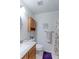 Bright bathroom with a vanity sink, wooden cabinet, purple rug, toilet, and shower at 12935 Lake Circle Dr, Thornton, CO 80241