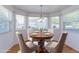 Sunlit breakfast nook with a round wooden table, chairs, and large windows at 12935 Lake Circle Dr, Thornton, CO 80241