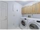 Convenient laundry room with washer, dryer, and overhead cabinets for storage at 12935 Lake Circle Dr, Thornton, CO 80241