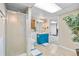 Bathroom with blue vanity, shower with glass door, and a patterned tile floor at 1490 S Salem Way, Aurora, CO 80012