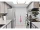 Galley kitchen featuring stainless steel appliances and stone countertops, with a skylight at 1490 S Salem Way, Aurora, CO 80012