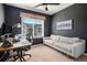 Stylish home office featuring dark walls, neutral sofa, and a large desk at 1558 Castle Creek Cir, Castle Rock, CO 80104