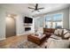 Cozy living room with a fireplace, plush leather sofa, and a modern ceiling fan at 1558 Castle Creek Cir, Castle Rock, CO 80104