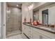 Bright bathroom featuring a glass-enclosed shower, double vanity with modern fixtures, and decorative tile floors at 5185 Vivian St, Wheat Ridge, CO 80033