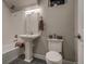 Clean and functional bathroom with a pedestal sink, tiled tub, and modern toilet at 5185 Vivian St, Wheat Ridge, CO 80033