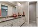 Dual vanity bathroom with white cabinets and a large mirror at 5185 Vivian St, Wheat Ridge, CO 80033